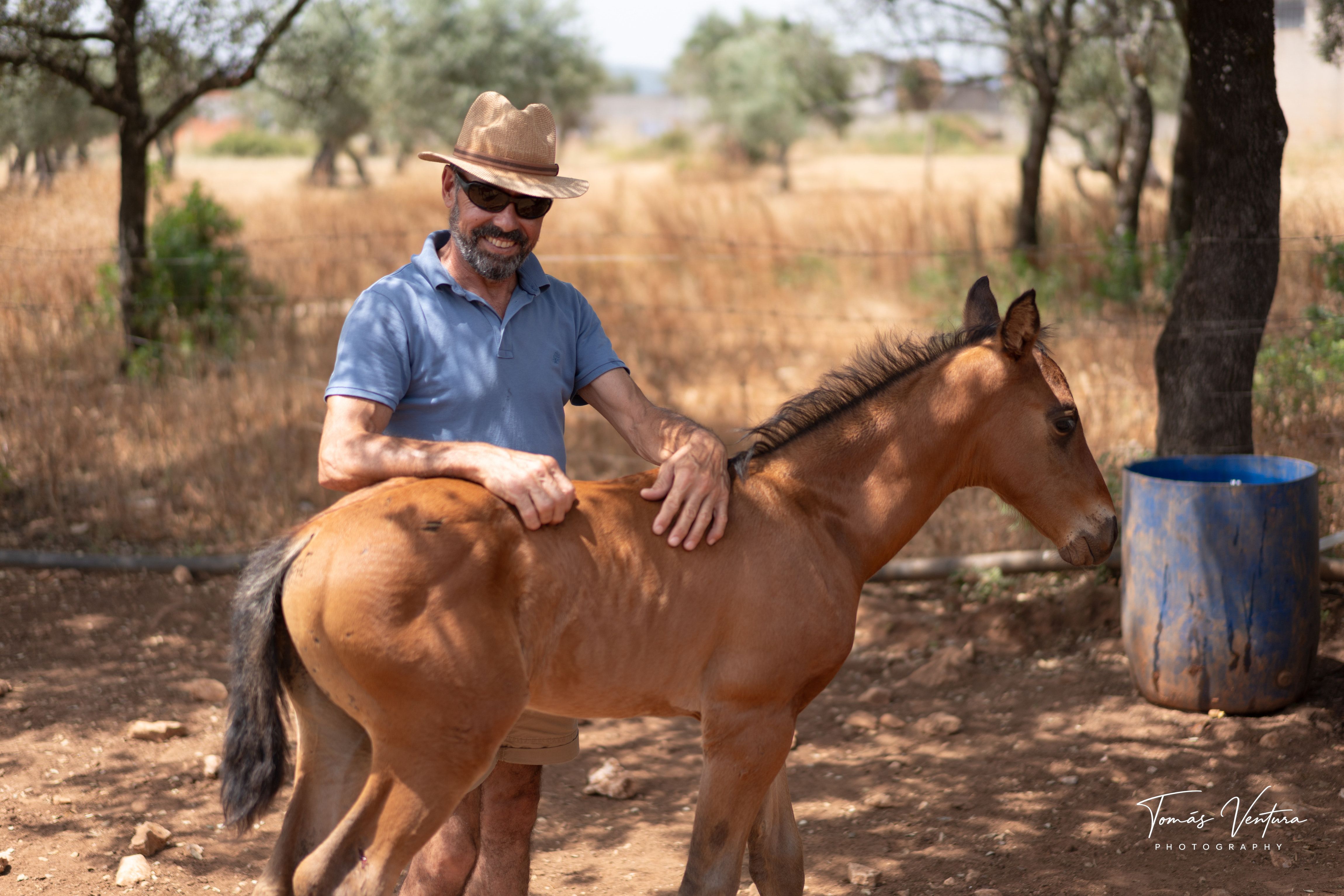 Jorge Ventura rests both hands on Xizel in the field.